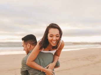 a man and woman hugging on a beach